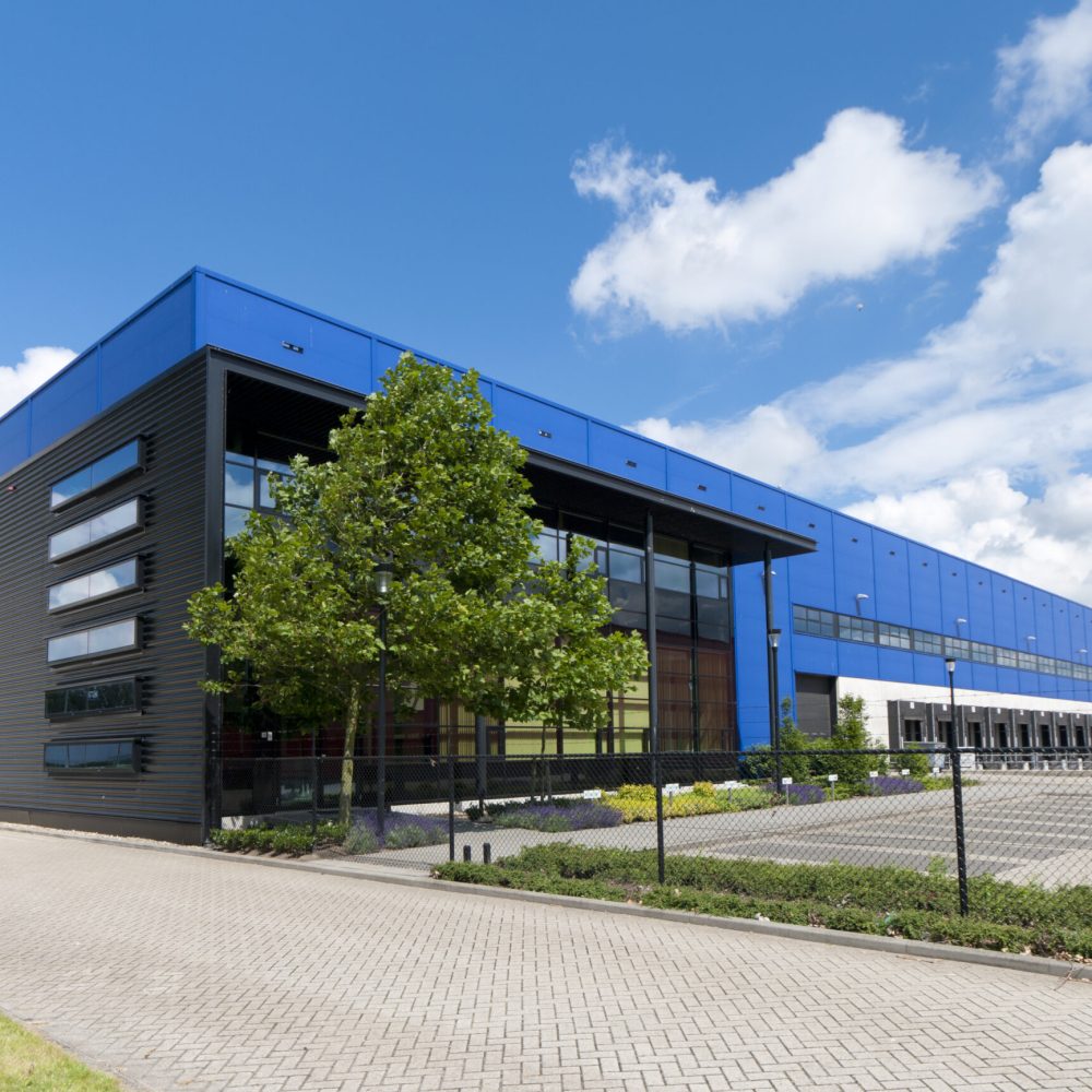 Modern logistikhall med blå fasad – Hallkonsulten Modern logistikhall med blå fasad och lasthus – Hallkonsulten