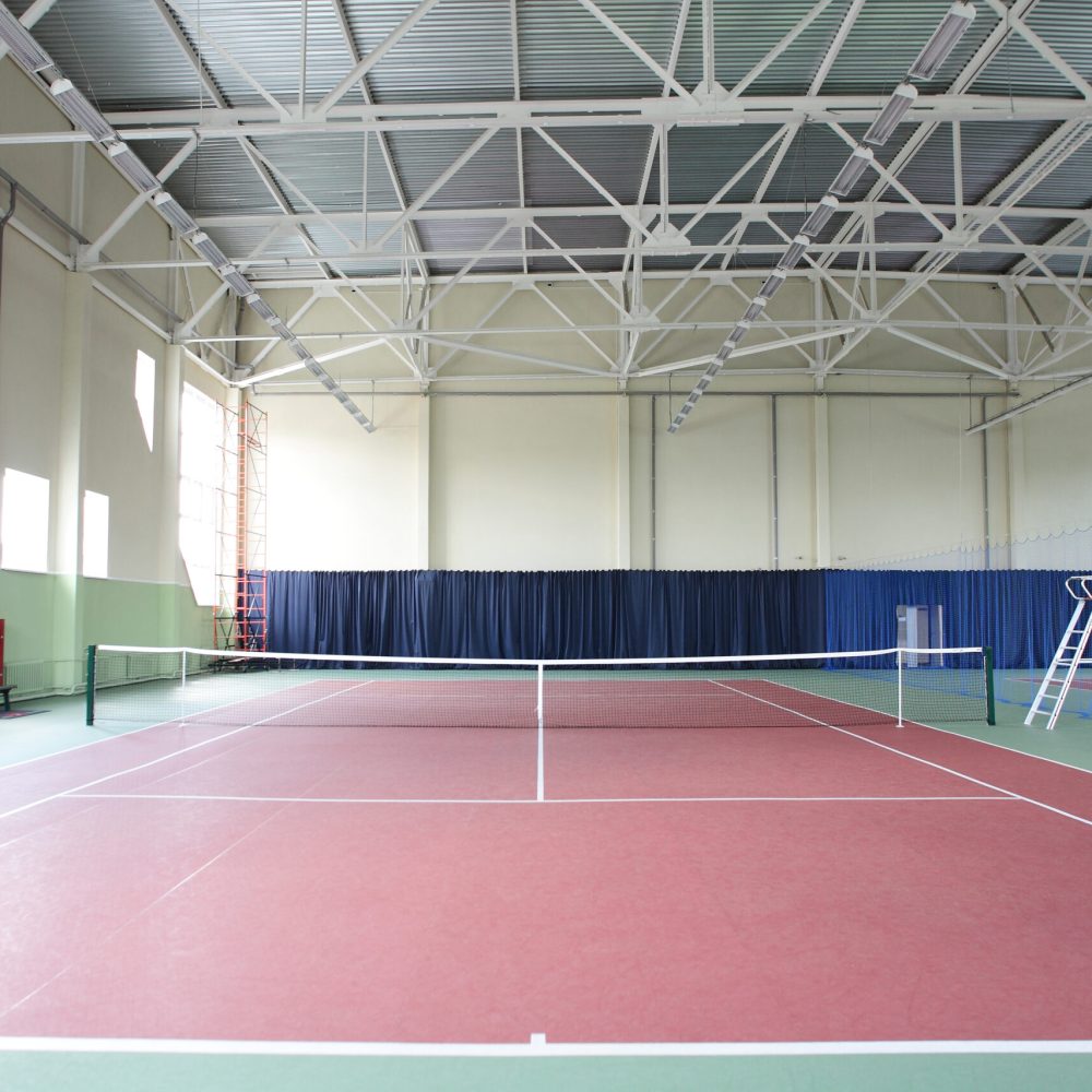 Interiör av sporthall med tennisbanor – Hallkonsulten Interiör av sporthall med tennisbanor och stålkonstruktion – Hallkonsulten