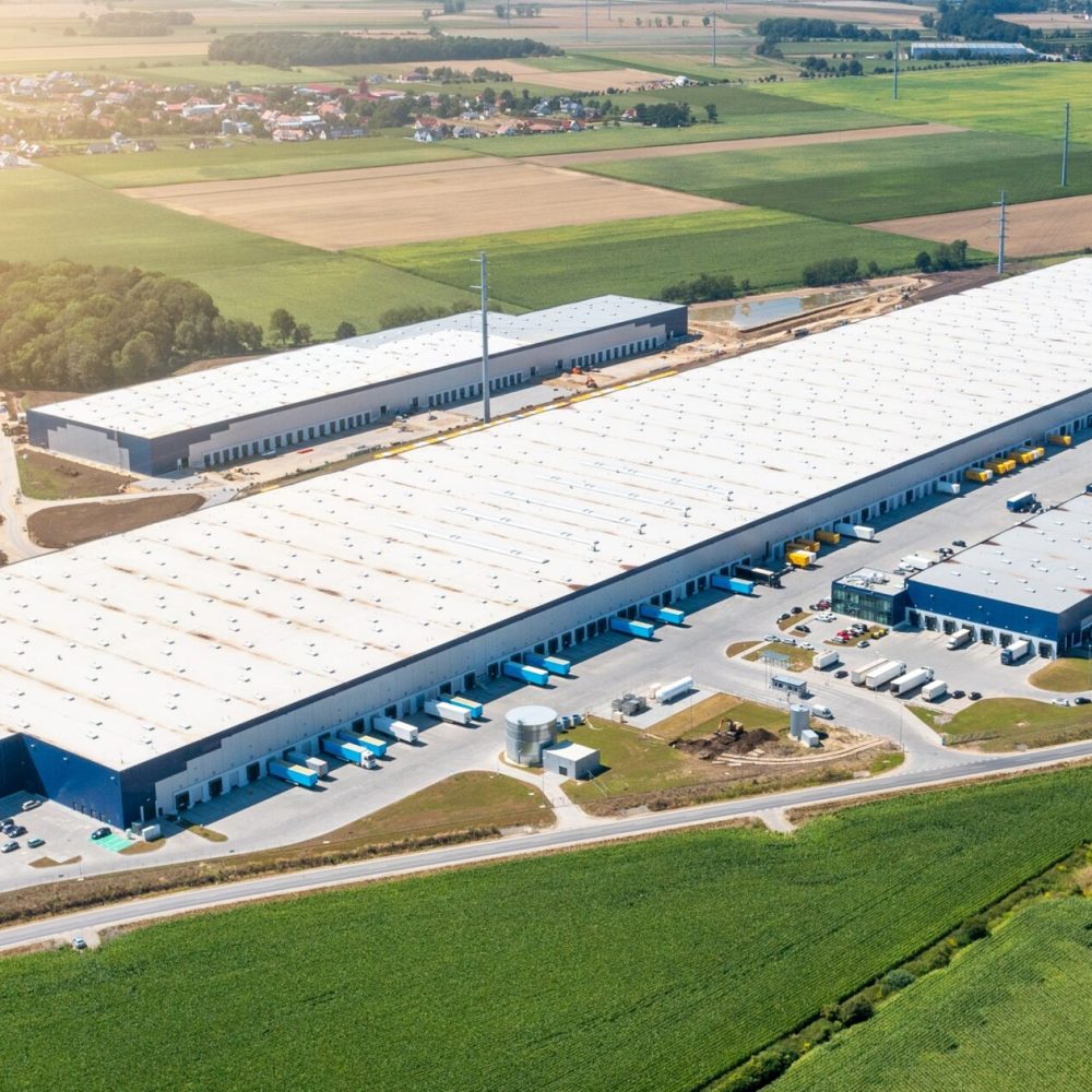 Flygfoto över logistikcenter och moderna logistikhallar – Hallkonsulten Flygfoto över stort logistikcenter och moderna logistikhallar – Hallkonsulten